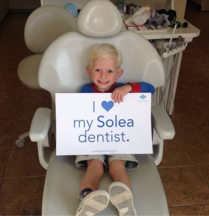 Young patient holding up Laser Solea sign.